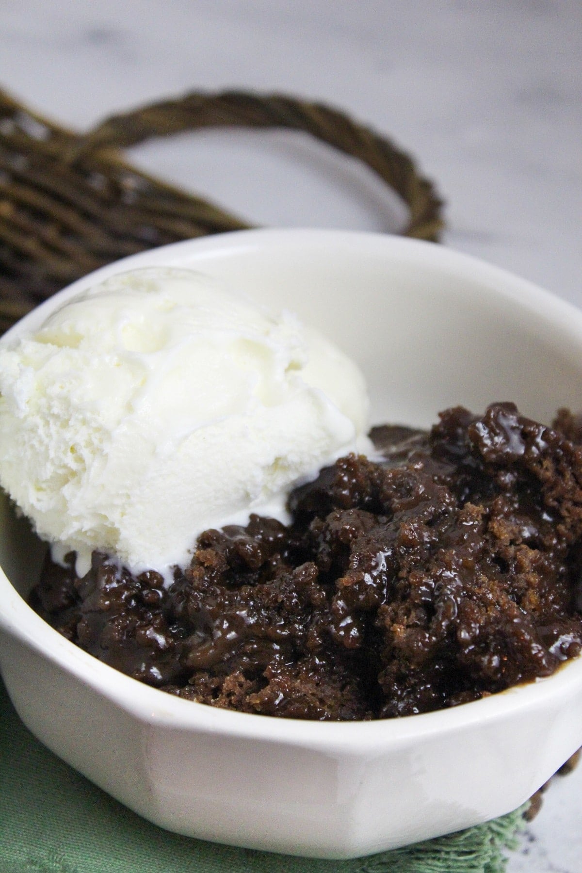 slow cooker chocolate cobbler in a bowl with vanilla ice cream
