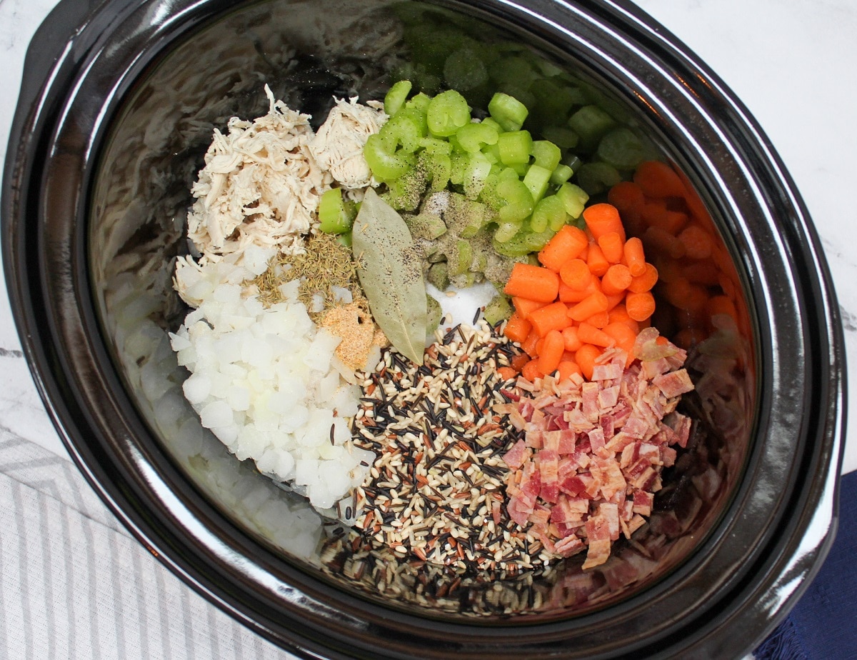 Chicken and wild rice soup ingredients in a slow cooker