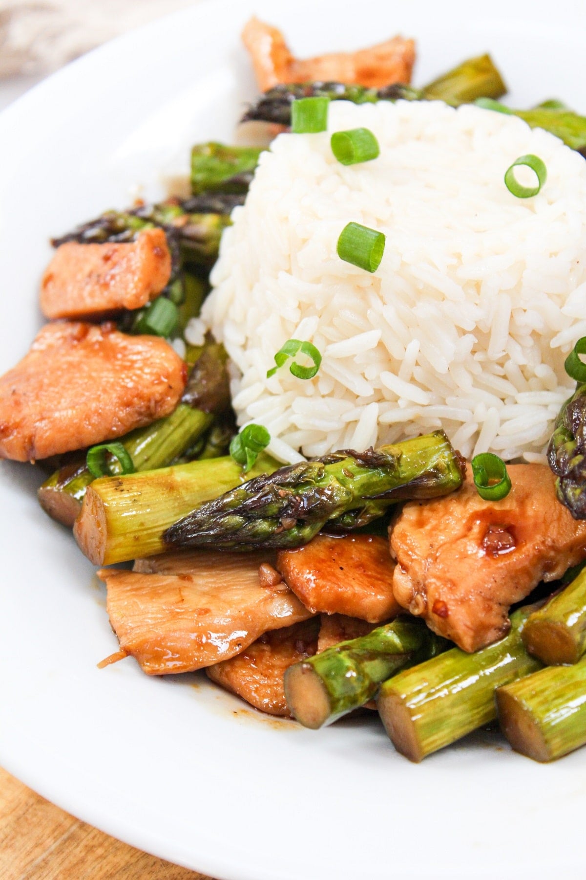 chicken and asparagus stir fry in a bowl with rice.