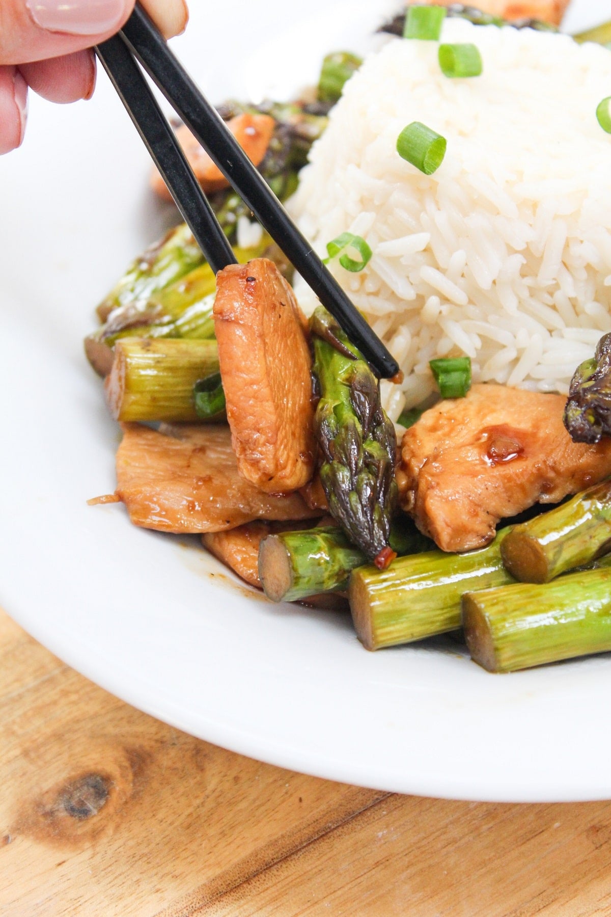 chicken and asparagus stir fry with chopsticks.