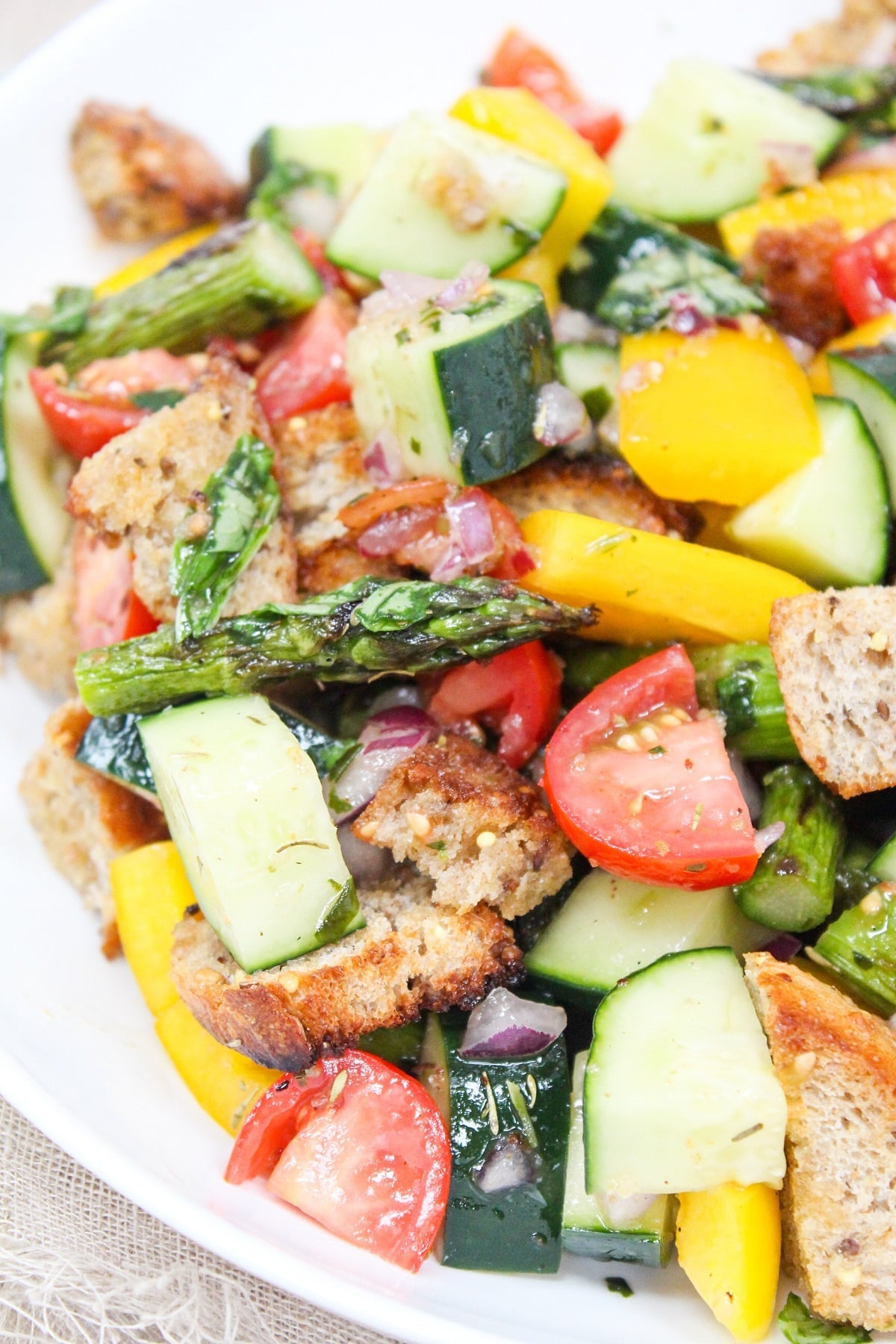 asparagus panzanella salad in a white bowl.