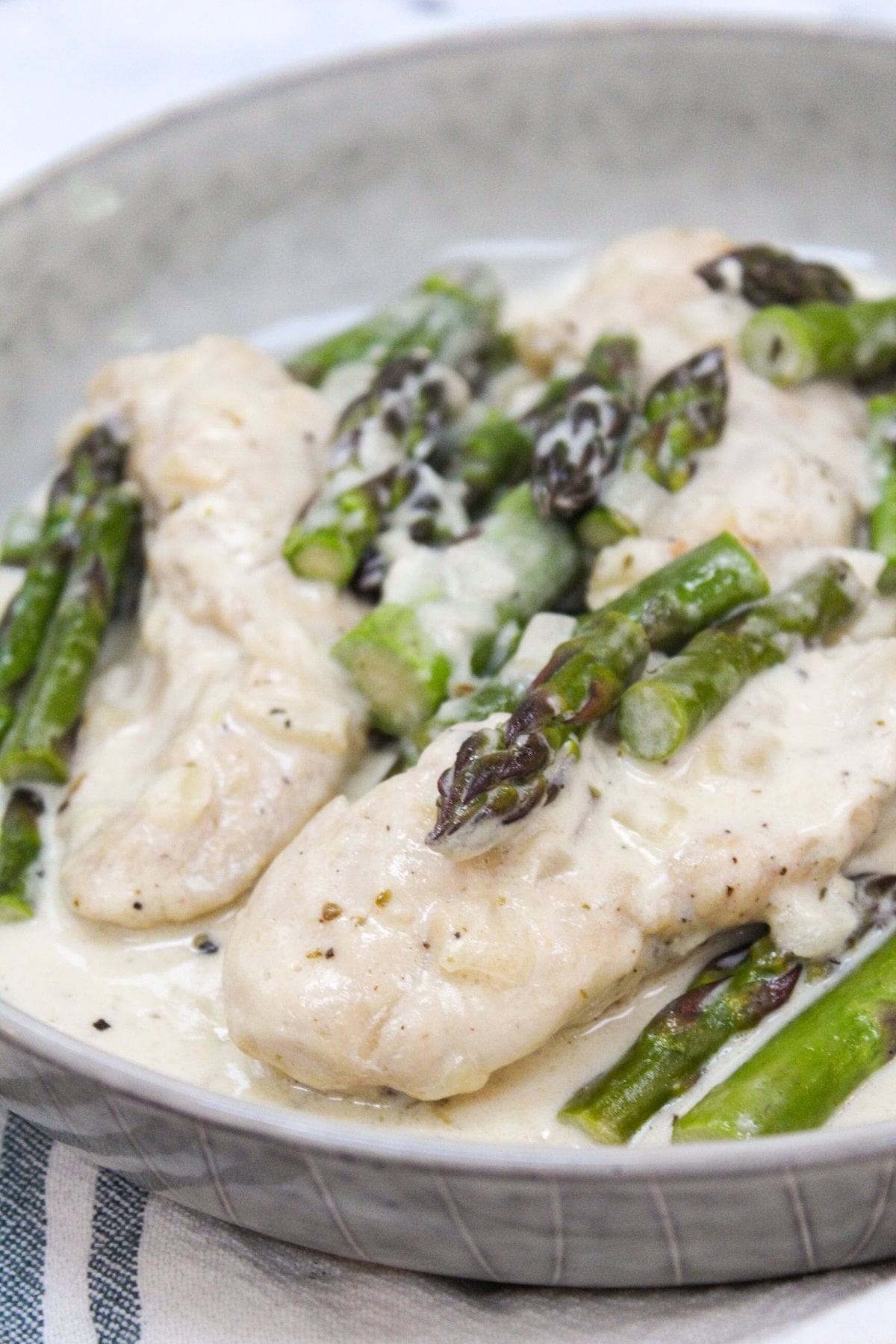 creamy keto chicken and asparagus in a skillet.