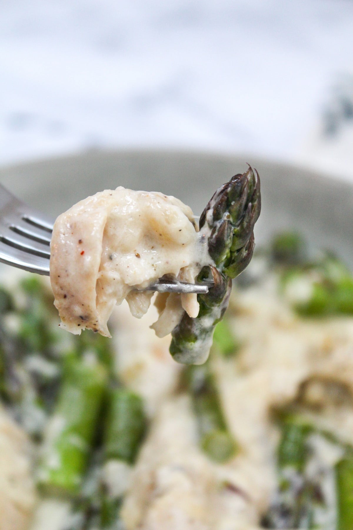 creamy keto chicken and asparagus on a fork.