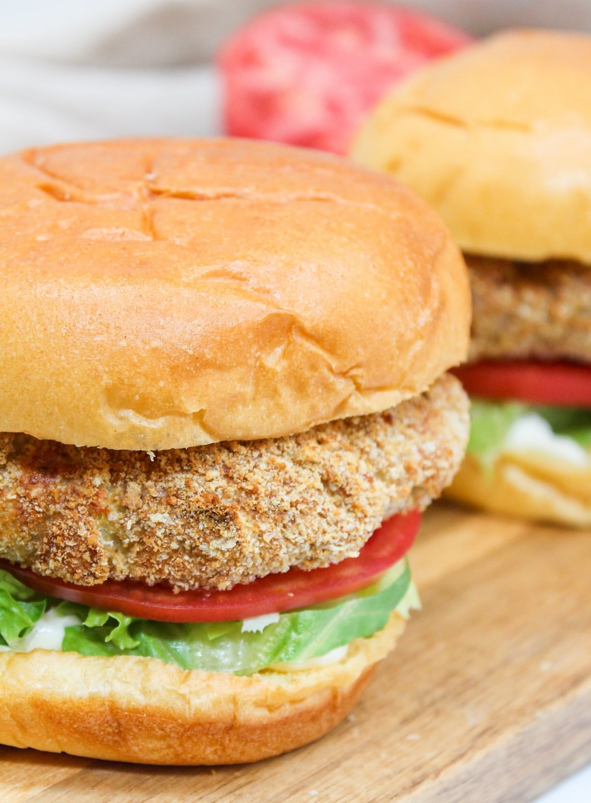 crispy chicken patty on a bun with shredded lettuce and sliced tomato.