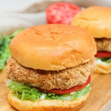 crispy chicken patty on a bun with shredded lettuce and sliced tomato.