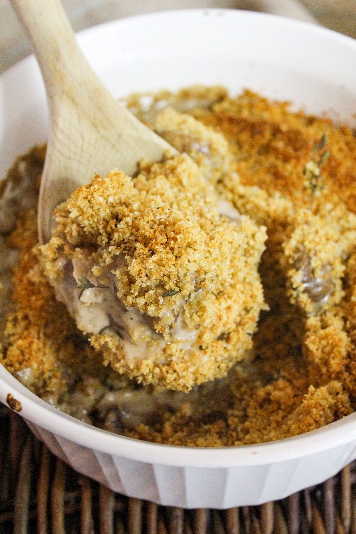 creamy mushrooms baked with a breadcrumb topping lifted from the dish with a spoon.