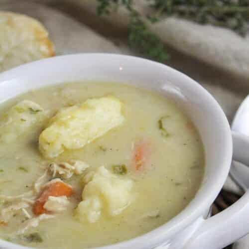 white bowl with creamy turkey soup and round dumplings.