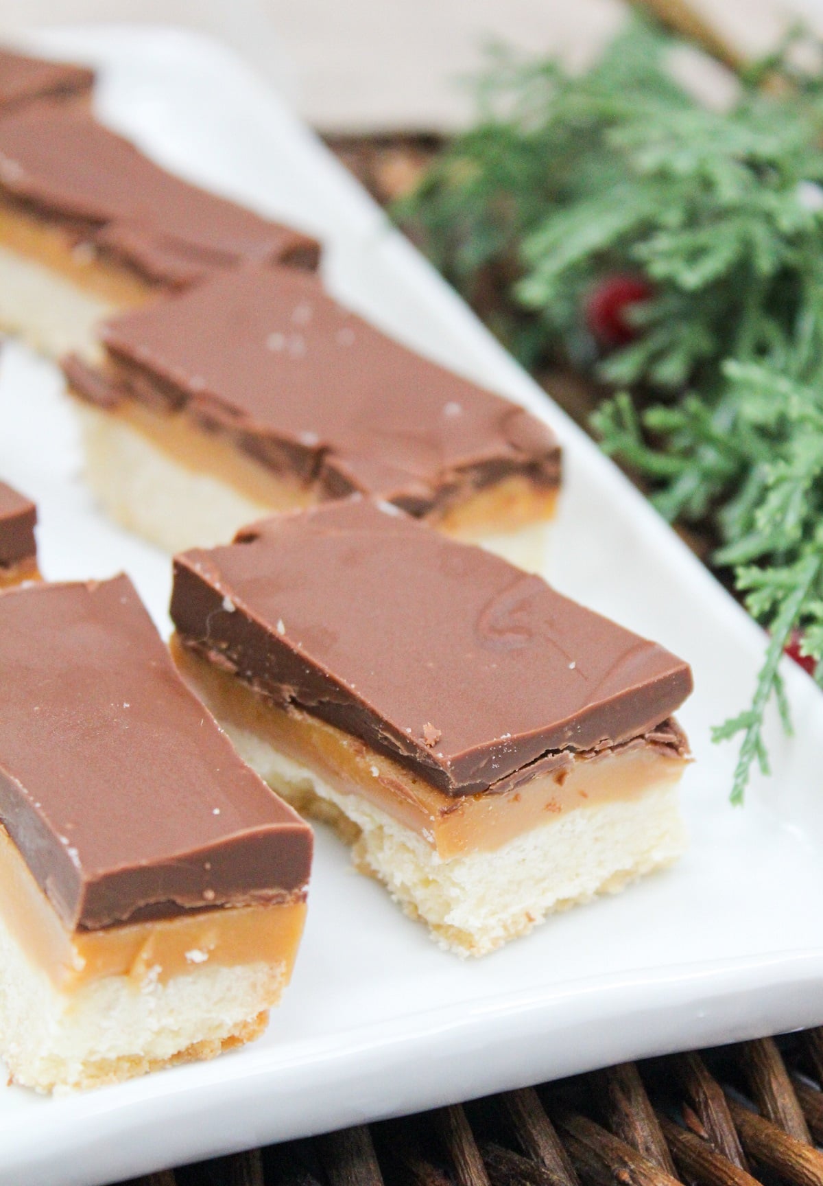 Cookie style bars cut into rectangles. The bars are layers wit h shortbread on the bottom, then caramel, and chocolate on top.