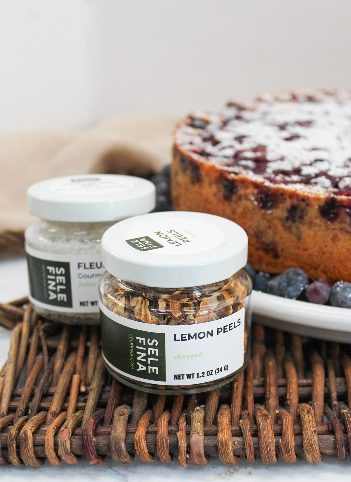 bottles of spices next to a blueberry lemon cake.