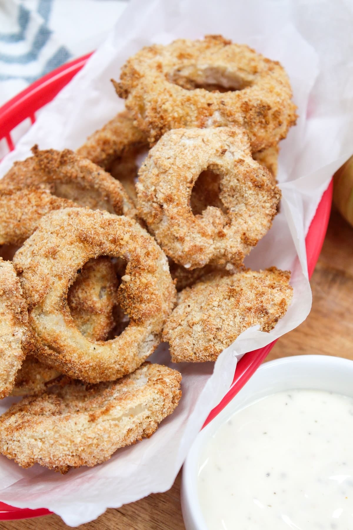 cooked onion rings in a red basket.
