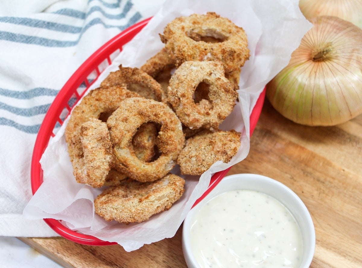 cooked onion rings in a red basket.