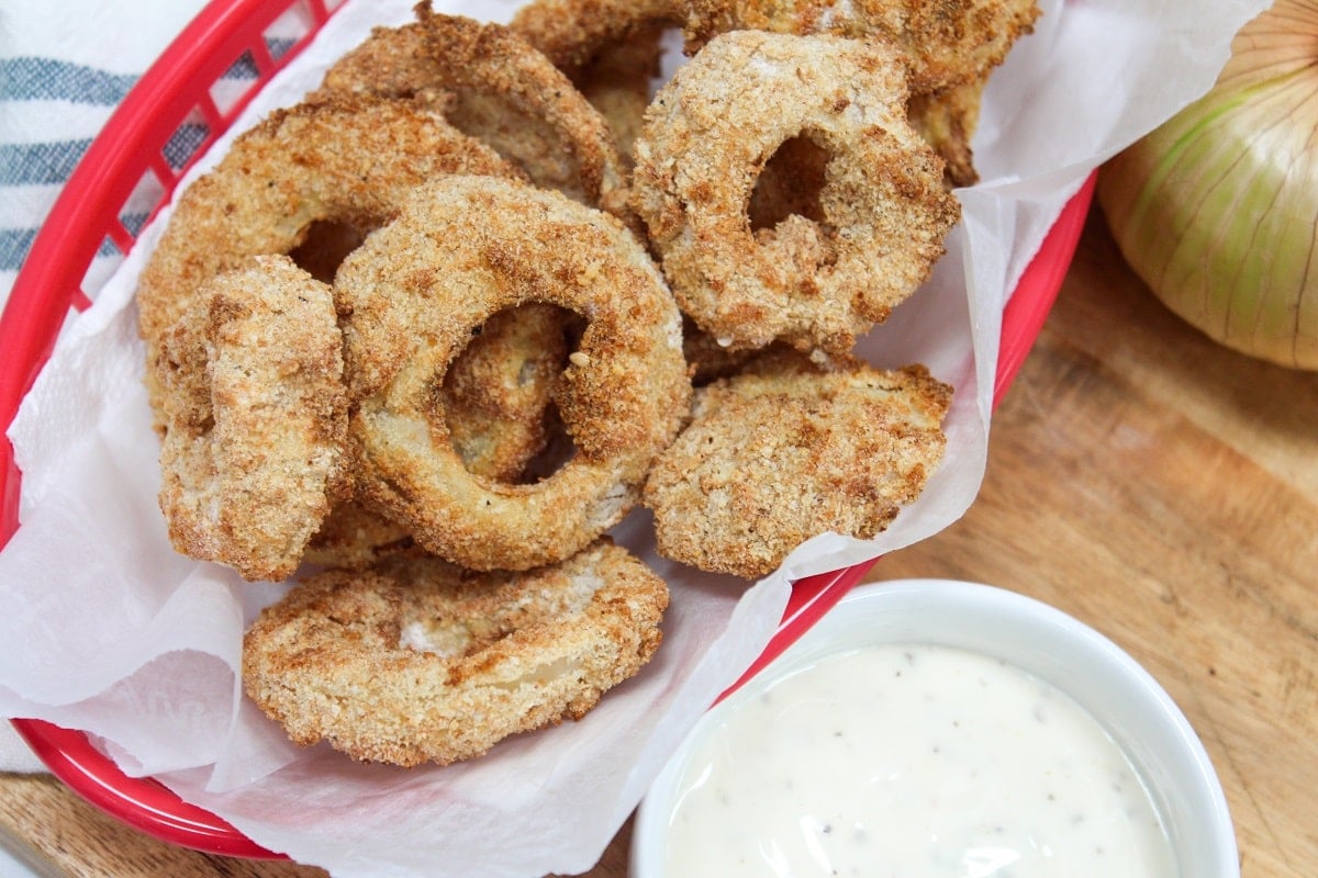 cooked onion rings in a red basket.
