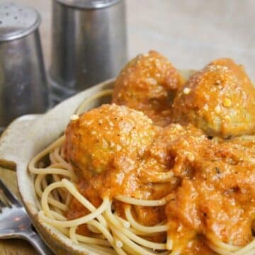 Meatballs cooked in a creamy tomato sauce over spaghetti.
