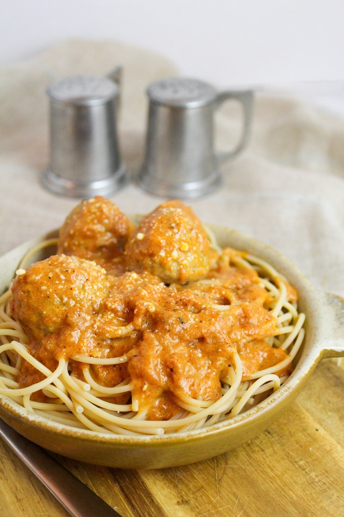 Meatballs cooked in a creamy tomato sauce over spaghetti.