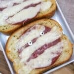 Garlic toast topped with melted white cheese with candy eyeballs.