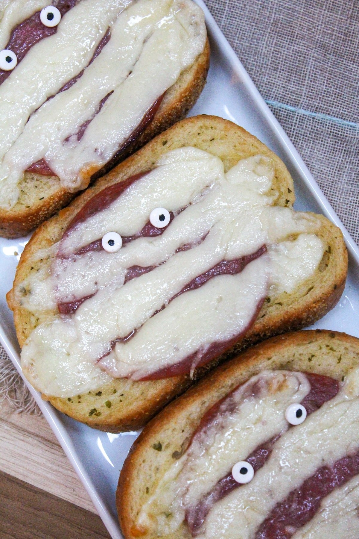 Garlic toast topped with melted white cheese with candy eyeballs.