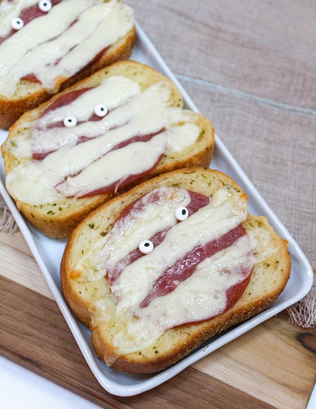 Garlic toast topped with melted white cheese with candy eyeballs.