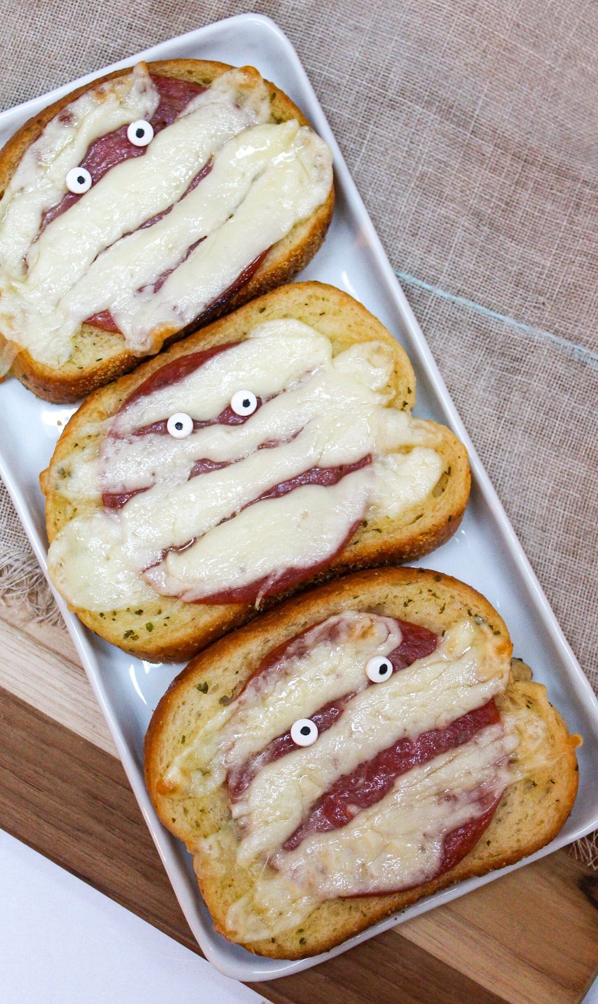 Garlic toast topped with melted white cheese with candy eyeballs.