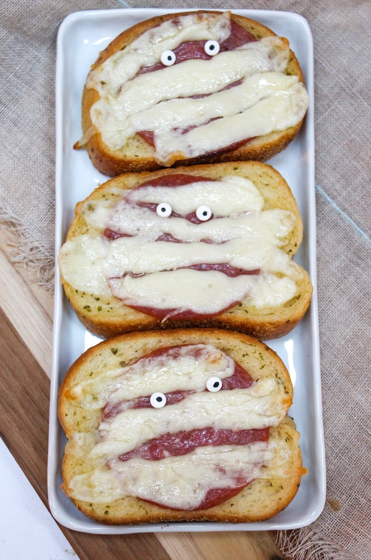 Garlic toast topped with melted white cheese with candy eyeballs.