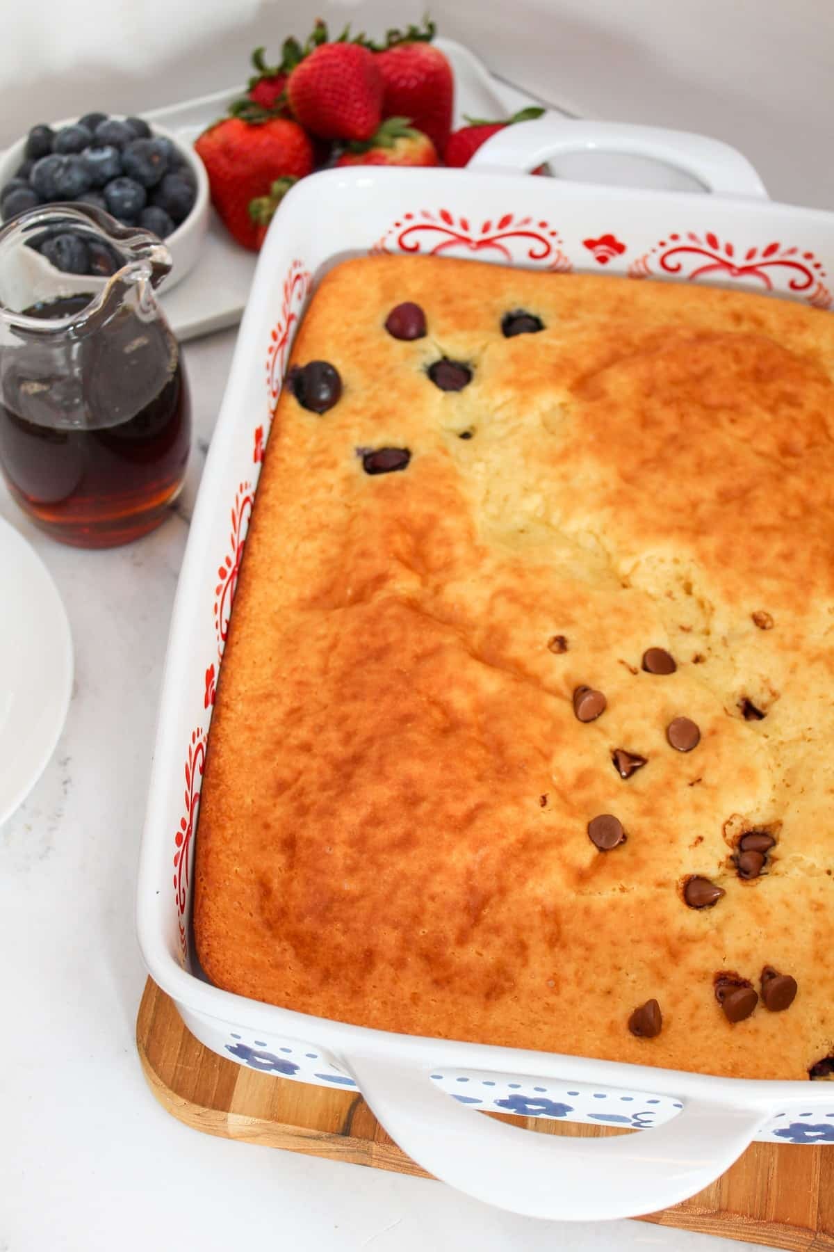 9x13 casserole pan with a pancake baked. Topped with blueberries in one section and one section of chocolate chips.