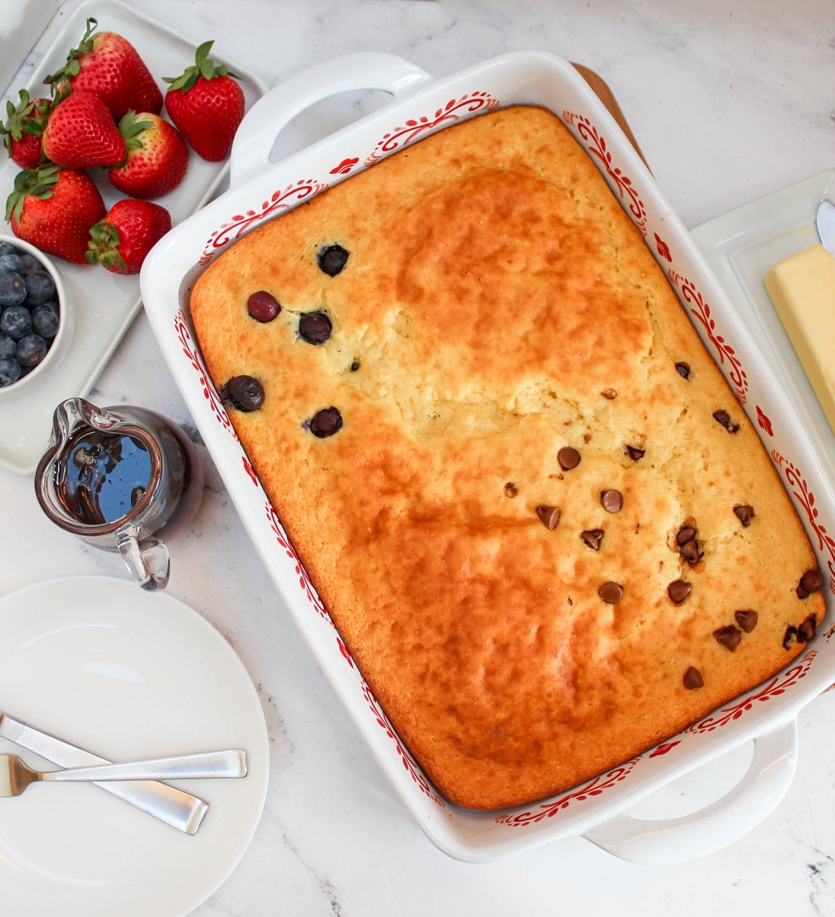 9x13 casserole dish with a pancake baked. Topped with blueberries in one section and one section of chocolate chips.